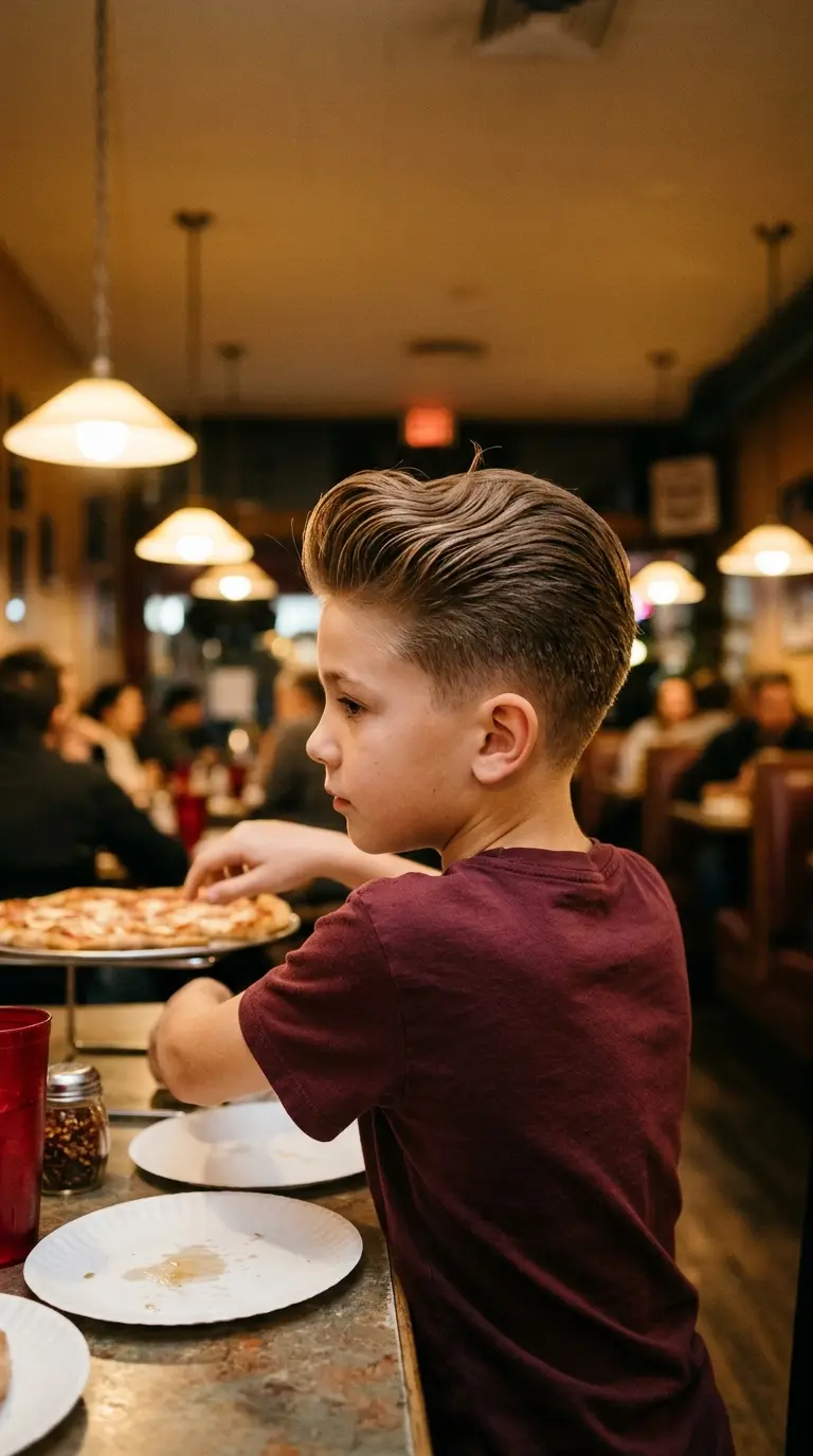 Three quarter back view of a boy with a brushed up mini pompadour