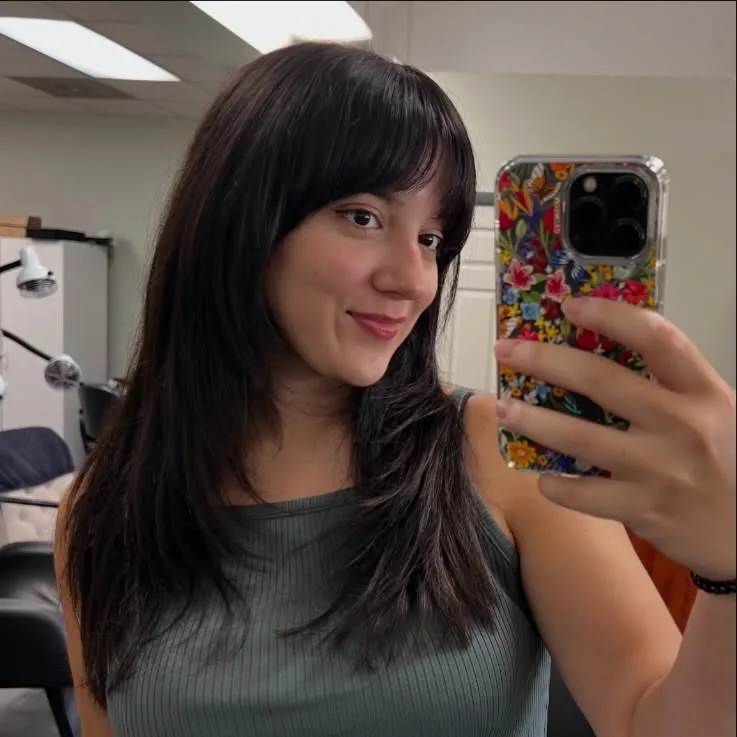 Wolf cut medium hair with bottleneck bangs in a mirror selfie