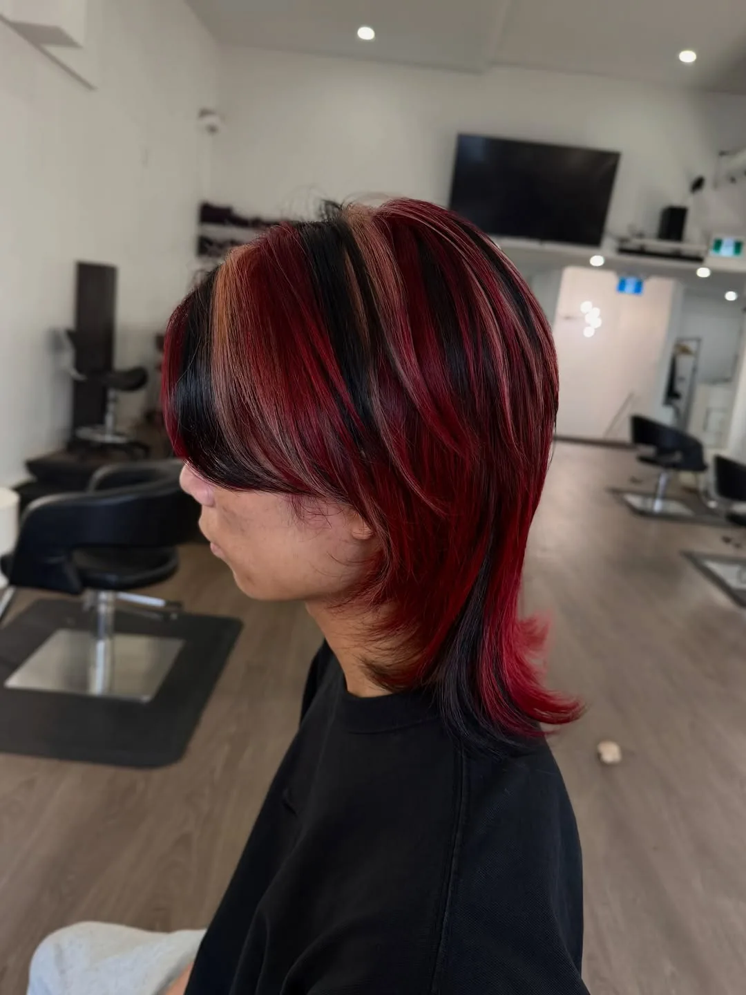 Edgy wolf mullet hybrid medium hair with red and black layers